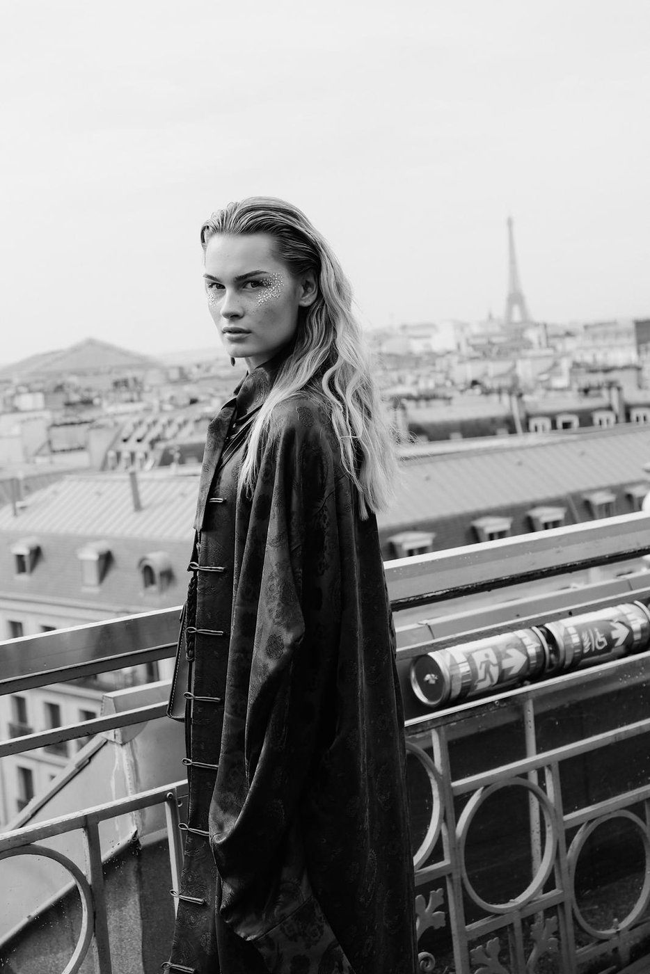 Portrait en noir et blanc, maquillage orné de cristaux, tour Eiffel en arrière-plan