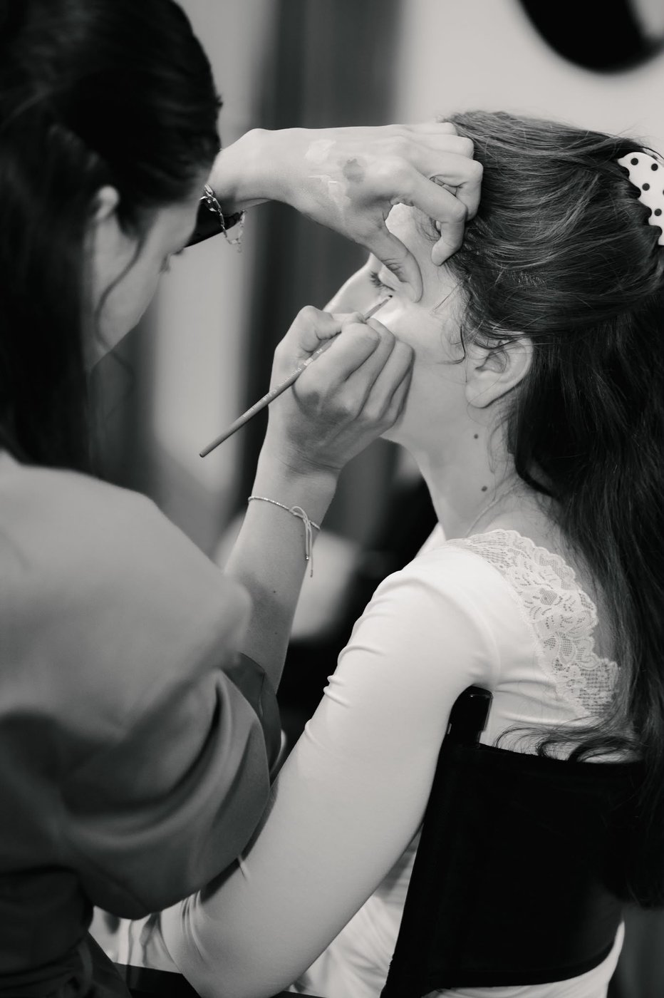 Maquillage des yeux d'une mariée au pinceau, photo en noir et blanc