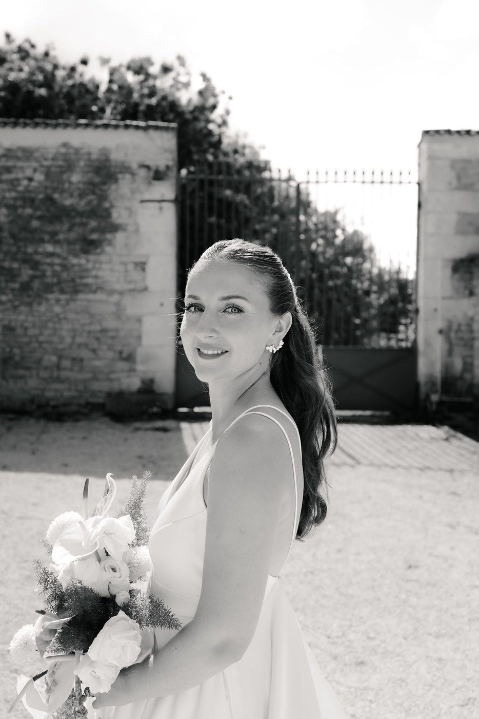 Portrait de mariée souriante avec son bouquet, noir et blanc